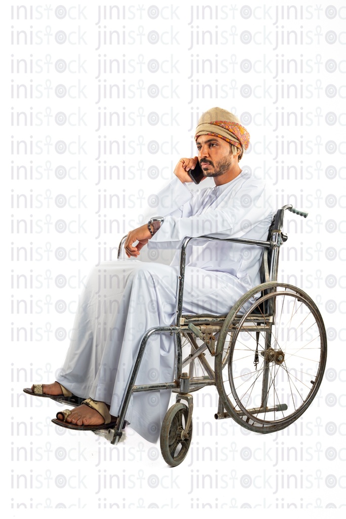 omani khaliji arab man from gulf on a wheel chair talking on the mobile