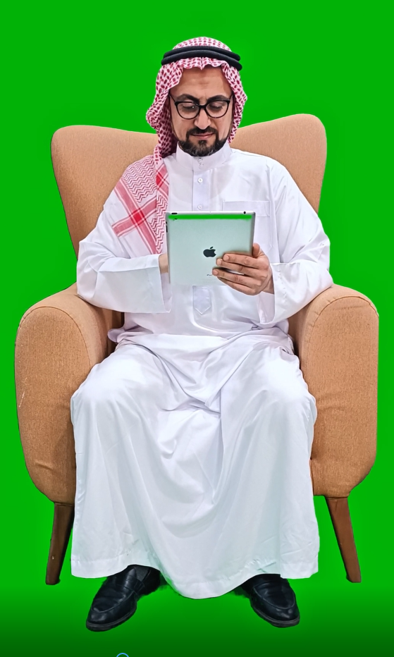 خليجي عربي سعودي من الخليج يعمل على جهاز الآيباد الخاص به على كرسي