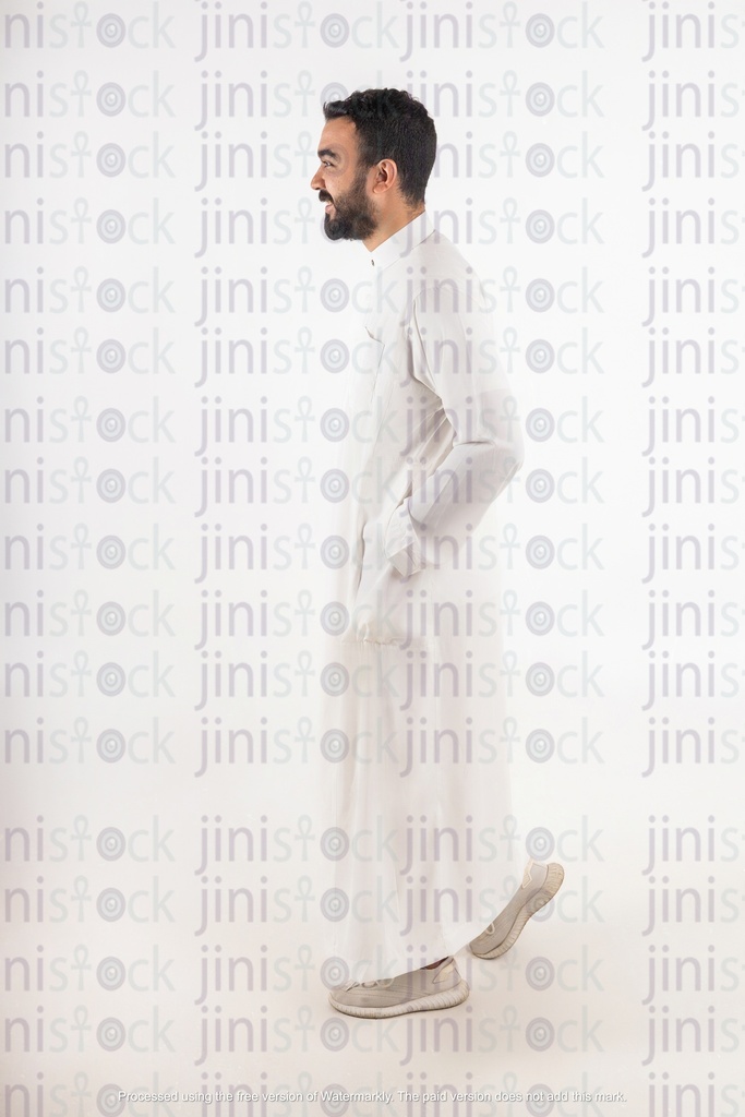 رجل خليجي يمشي في وضع جانبي على خلفية معزولة