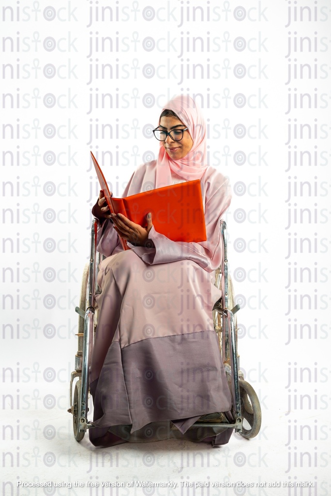امرأة خليجية سعودية من الخليج على كرسي متحرك تنظر إلى ملف أو مجلد عمل