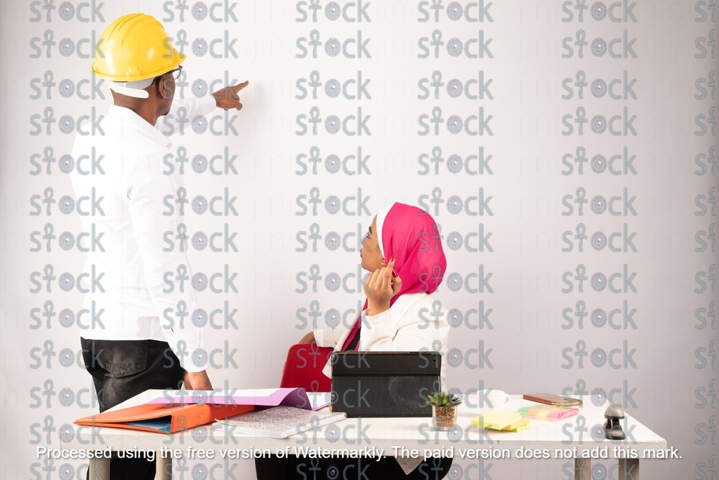 A veiled Nubian girl sitting next to a Nubian young man who is pointing at something