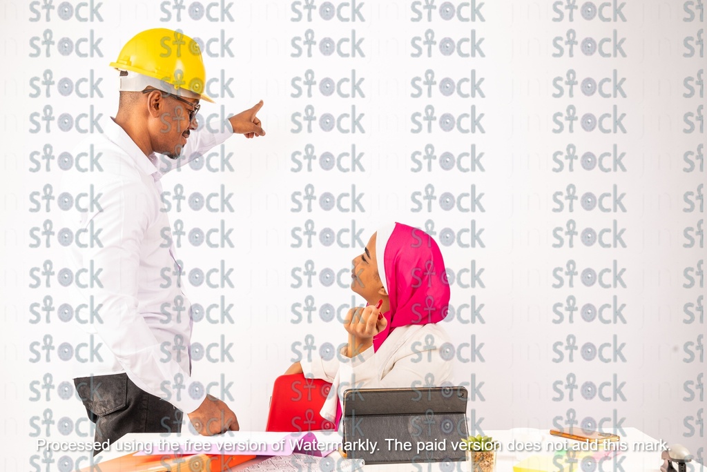 A veiled Nubian girl sitting next to a Nubian young man wearing a yellow hat
