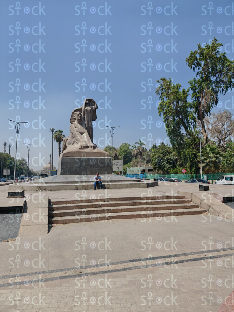 An inviting side view of the statue with a person seated below