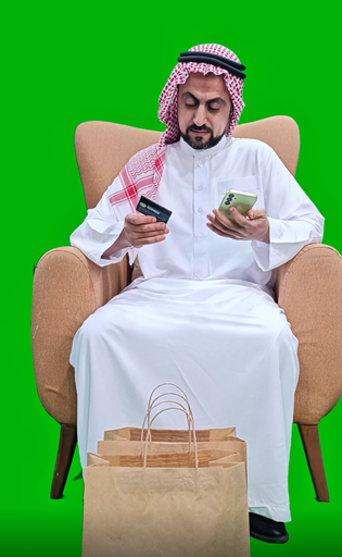 khaliji saudi arab man from gulf shopping online on his mobile while sitting in the living