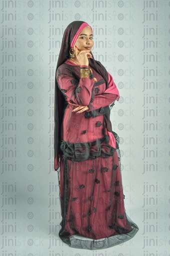 A Nubian woman from Egypt wearing Nubian clothes and putting her hand on her cheek