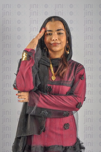 A Nubian Egyptian woman wearing Nubian clothes, putting a cover on her hair, and putting her hand on her face