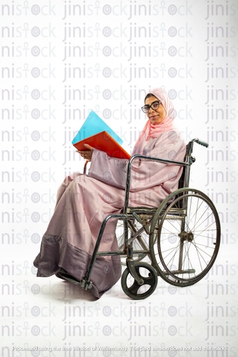 saudi khaliji woman from the gulf on a wheel chair disabled and  looking to the camera while holding a folder of a work file