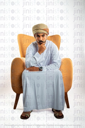 omani man khaliji from gulf sitting on the chair focused looking to the camera thinking may be upset