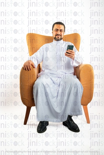 saudi khaliji man sitting on the chair checking his mobile phone