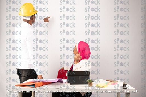 A veiled Nubian girl sitting next to a Nubian young man who is pointing at something