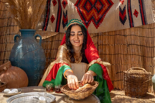 A smiling Egyptian peasant woman starts eating breakfast 