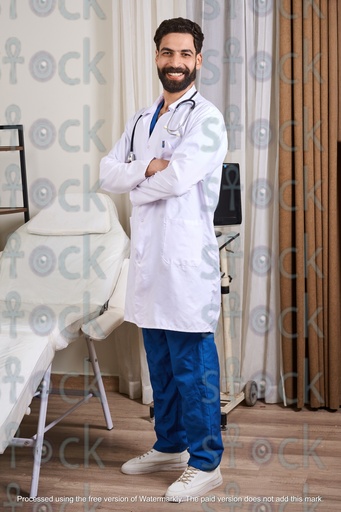 A smiling doctor standing in his clinic wearing a medical coat and a stethoscope