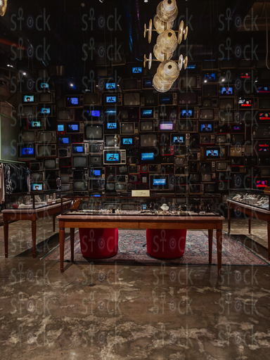 طاولة عرض مجوهرات أمام جدار تلفزيونات