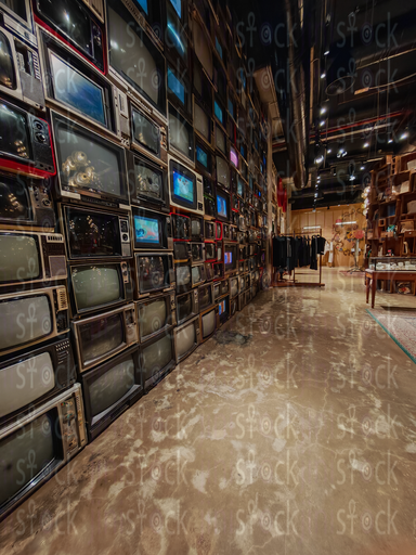 A walkway by a wall of TVs