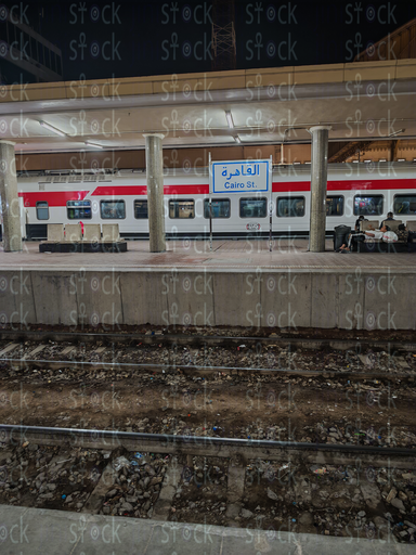 Red and White Train Under the Station Lights 